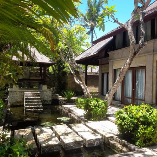 a house with a pond in front of it at The Royal Beach Seminyak Bali in Seminyak