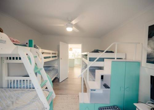 a room with two bunk beds and a staircase at Shellwater at Sellicks Beach Large Double Block Coastal Family Getaway in Sellicks Beach