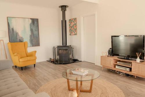 a living room with a couch and a tv and a table at Shellwater at Sellicks Beach Large Double Block Coastal Family Getaway in Sellicks Beach