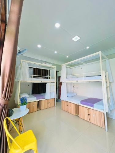 two bunk beds in a room with a yellow chair at Amy 2 Hostel Hue in Hue
