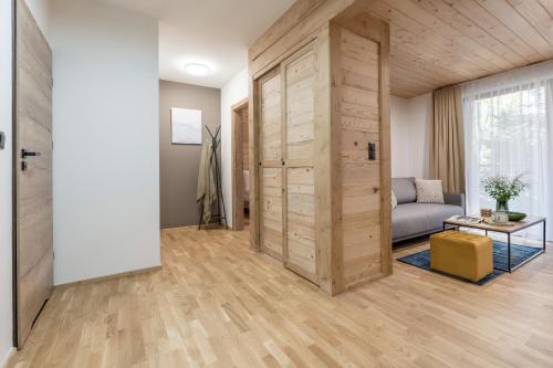 a living room with a couch and a wooden door at Apres Ski Bachleda - LoftAffair Collection in Zakopane