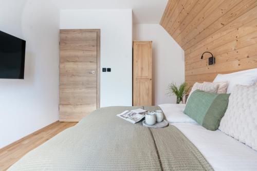 a bedroom with a large white bed with a television at Apres Ski Bachleda - LoftAffair Collection in Zakopane