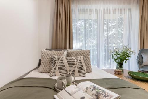 a bedroom with a bed with pillows and a window at Apres Ski Bachleda - LoftAffair Collection in Zakopane