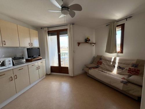 Il comprend une cuisine avec un canapé et un ventilateur de plafond. dans l'établissement Appartement T2 avec loggia, parking privé et proche plage, Port Leucate - FR-1-81-615, à Leucate