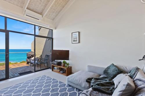 a living room with a couch and a view of the ocean at 13 Whitecrest Great Ocean Road Resort - Ocean Views in Wongarra