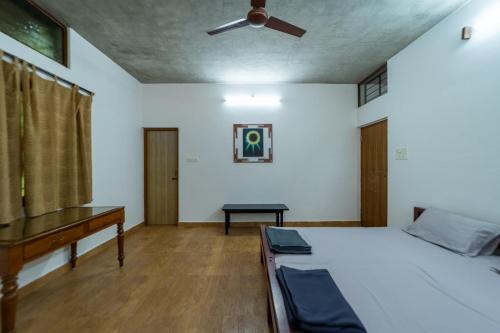 a bedroom with a bed and a piano at Aurovidya Retreat in Kottakupam