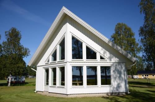 a white house with large windows on a field at Storstrand Kursgård in Piteå