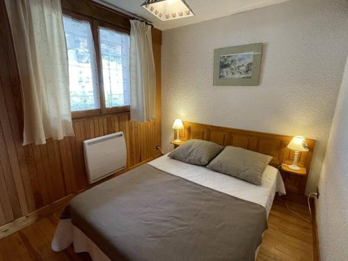 une chambre avec un lit avec deux lampes et une fenêtre dans l'établissement Appartement 2 pièces à 500m du centre, 5 couchages - FR-1-810-9, aux Saisies
