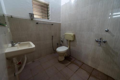 a bathroom with a toilet and a sink at Aurovidya Retreat in Kottakupam