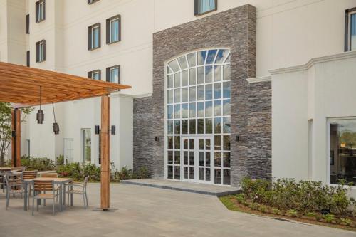 a patio with tables and chairs in front of a building at Staybridge Suites - Irapuato by IHG in Irapuato