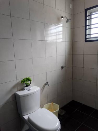 a bathroom with a toilet with a plant on top of it at Seri Cempaka Homestay in Kluang