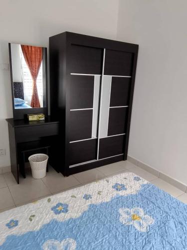a bedroom with a black cabinet and a blue rug at Seri Cempaka Homestay in Kluang