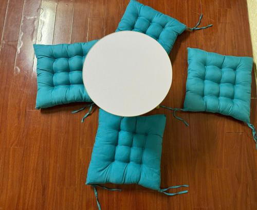 a white table and two blue cushions on a floor at Opera Hostel in Hanoi