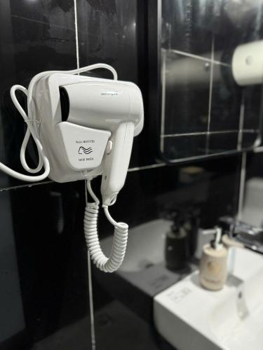 a hair dryer hanging on a wall next to a sink at Opera Hostel in Hanoi