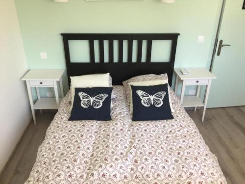 a bedroom with a bed with butterflies pillows on it at Chambres avec petit déj inclus et table d'hôtes en Berry, près des Châteaux de la Loire - FR-1-591-700 in Fontguenand