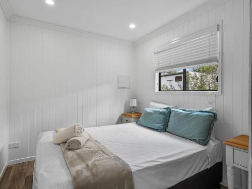 a bedroom with a bed with blue pillows and a window at Crows Nest Tourist Park in Crows Nest