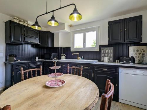 - une cuisine avec une table en bois dans l'établissement Chambre Verte avec Jardin partagé près du Puy-en-Velay - FR-1-582-498, à Rosières