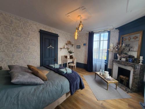 une chambre avec un lit, une table et une cheminée dans l'établissement Chambre cosy avec petit-déj & services bien-être - FR-1-589-720, à Médonville