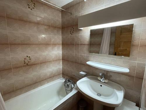 une salle de bain avec un lavabo, un miroir et une baignoire dans l'établissement Appartement 2 pièces à 500m du centre, 5 couchages - FR-1-810-9, aux Saisies