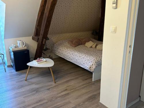 a small bedroom with a bed and a table at Chambres avec petit déj inclus et table d'hôtes en Berry, près des Châteaux de la Loire - FR-1-591-700 in Fontguenand