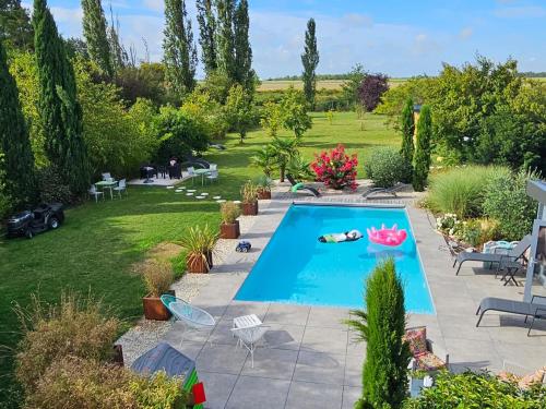 une vue aérienne d'une piscine dans un jardin dans l'établissement Chambre Cheverny: Maison d'hôtes avec piscine chauffée & petit-déjeuner inclus - FR-1-590-489, à Messas