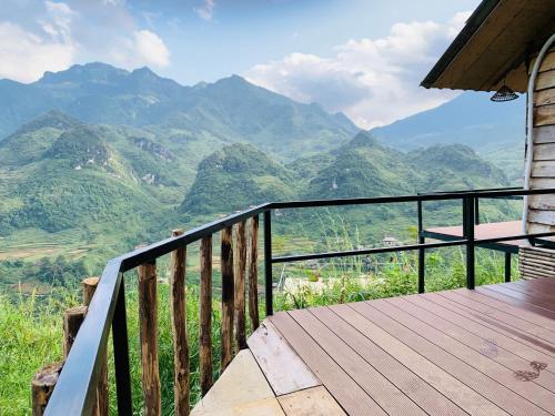 a wooden balcony with a view of mountains at Du peak home in Làng Cac
