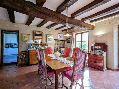 une cuisine et une salle à manger avec une table et des chaises en bois dans l'établissement Charmantes chambres d'hôtes avec petit-déjeuner à Azay-le-Ferron - FR-1-591-674, à Azay-le-Ferron
