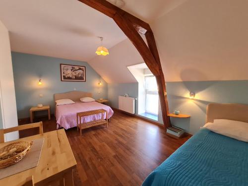 une chambre avec deux lits et une table dans l'établissement Ferme rénovée près de Beaugency, 4 chambres, petit-déjeuner maison, proche Loire à Vélo - FR-1-590-445, à Cravant