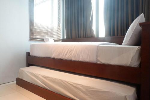 a bedroom with two beds and a window at Modern 2BR Apartment at Aryaduta Residence Surabaya Connected to CITO Mall By Travelio in Surabaya