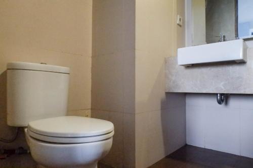 a bathroom with a white toilet and a sink at Modern 2BR Apartment at Aryaduta Residence Surabaya Connected to CITO Mall By Travelio in Surabaya