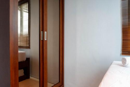 a bedroom with a mirror next to a bed at Modern 2BR Apartment at Aryaduta Residence Surabaya Connected to CITO Mall By Travelio in Surabaya