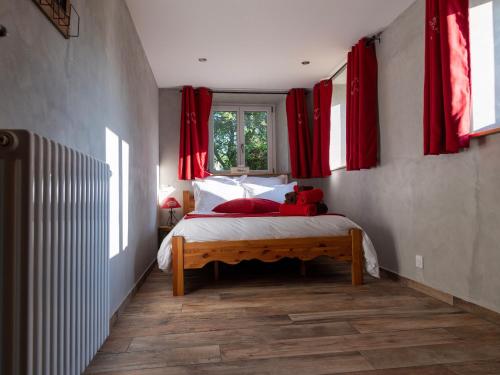 a bedroom with red curtains and a bed with a teddy bear on it at Chambre Jonquille avec entrée privée et animaux admis - FR-1-589-718 in Sapois