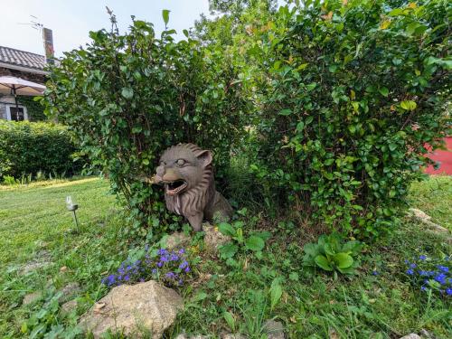 a statue of a dog in the grass at Maison d'hôtes rénovée avec table d'hôte dans la campagne Altiligérienne - FR-1-582-522 in Saint-Victor-sur-Arlanc