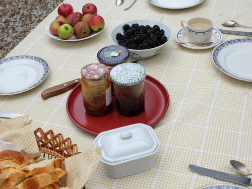 a table with jars of jam and fruit on it at Chambre spacieuse, entrée privée, animaux admis, WiFi - FR-1-590-513 in Presnoy