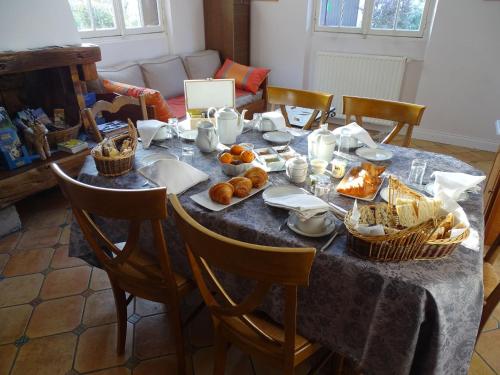 une table avec un chiffon de table bleu et des paniers de denrées alimentaires dans l'établissement Chambre d'hôtes 'Perle' avec WiFi, TV, petit-déjeuner inclus - FR-1-590-508, à Ligny-le-Ribault