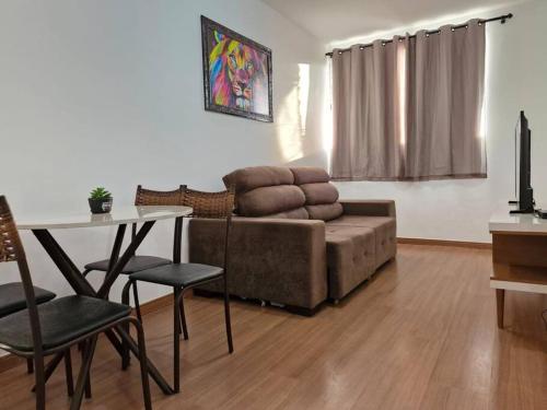 a living room with a couch and a table at Apto Aconchegante e Confortável! in Uberaba
