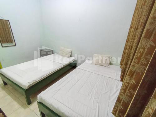 Кровать или кровати в номере Orange inn RedPartner Madiun