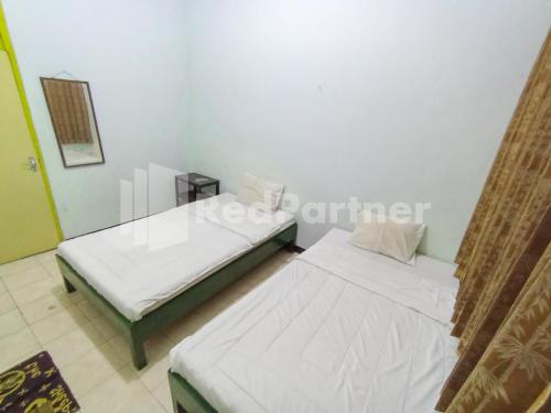 Кровать или кровати в номере Orange inn RedPartner Madiun