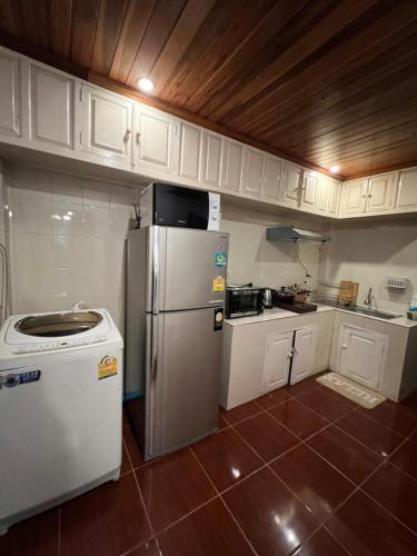 a small kitchen with a refrigerator and a stove at Xiengthong Villa in Luang Prabang