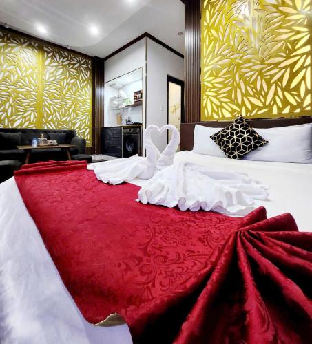 a bedroom with a large white bed with a red blanket at HA Hotel & Apartment in Vung Tau