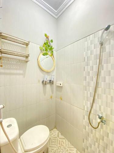a bathroom with a toilet and a mirror and a shower at Sedjuk Banguntapan Homestay in Bantul