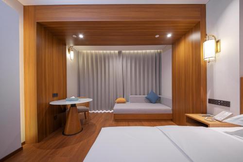 a bedroom with a bed and a table and a table at Wingate by Wyndham Libo Center in Libo