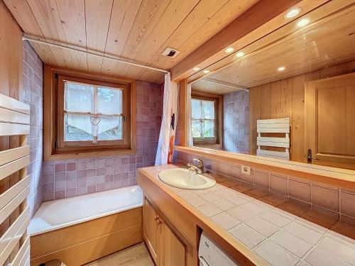 La salle de bains est pourvue d'un lavabo, d'une baignoire et d'une fenêtre. dans l'établissement Confortable 2 pièces avec jardin, parking, face au Mont Blanc - FR-1-560-152, à Combloux