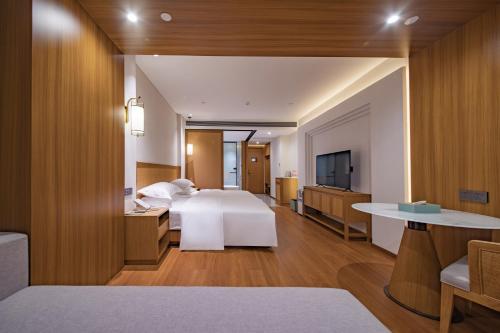 a hotel room with a bed and a television at Wingate by Wyndham Libo Center in Libo