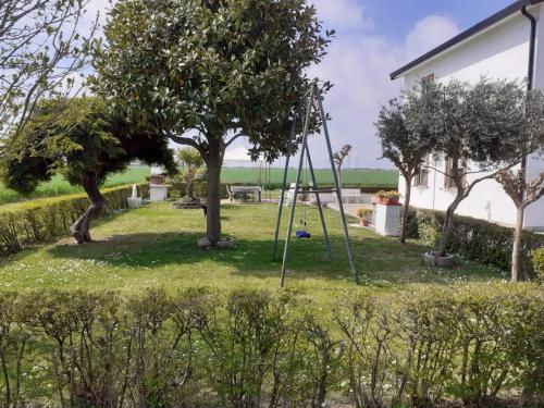 a swing in a yard next to a house at Locazione Turistica Girasole in Porto Tolle