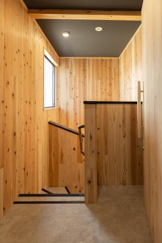 a wood paneled room with a door and a window at GOAT BASE 仲間と楽しく過ごせる貸切宿 stay in Nagano