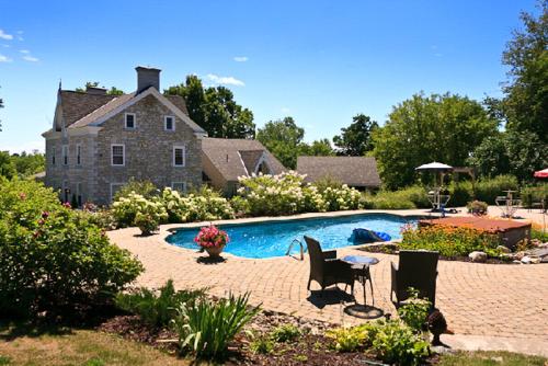 a backyard with a swimming pool and a house at Clyde Hall Bed and Breakfast in Lanark