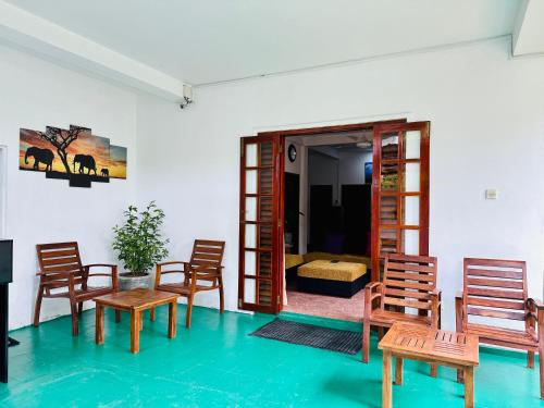 ゴールにあるTraveller's Lodge Unawatunaの木製の椅子付きの部屋、ベッド付きの部屋