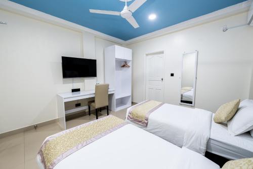 a bedroom with two beds and a desk at Air Residence 10978 in Hulhumale