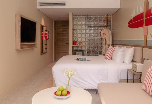 a hotel room with two beds and a table with a bowl of fruit at Soul Boutique Hotel Phu Quoc in Phu Quoc